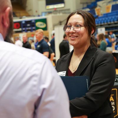 a student talks to a rep at the career fair